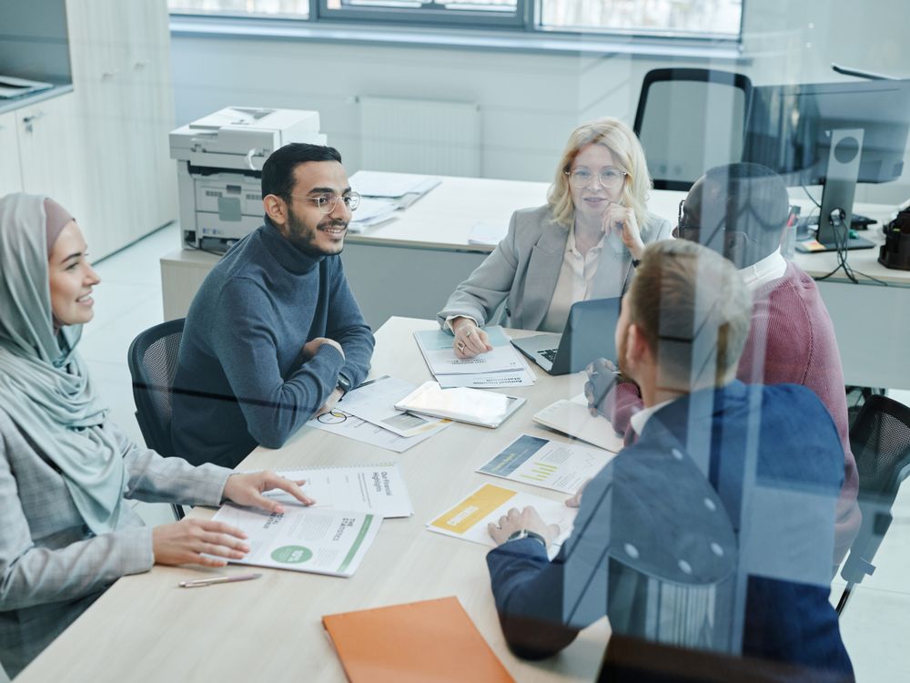 Digital marketing team collaborating around a table during a strategy meeting
